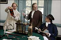 Gentlemen examining specimens and apparatus, including a vacuum machine.