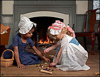 Alongside homemade ones, commercially produced toys became more common in the
eighteenth century, offering recreation and, betimes, social or moral
instruction to children. Maya Canaday, left, plays with Eleanor McCoy at the
Benjamin Powell House.