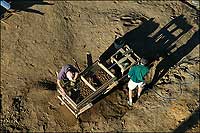 Luke Pecoraro, left, and Danny Schmidt, right, sift through dirt.