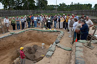 The chancel burials from 1608 are outlined, center, with colored flags marking the postholes for the church timber supports.